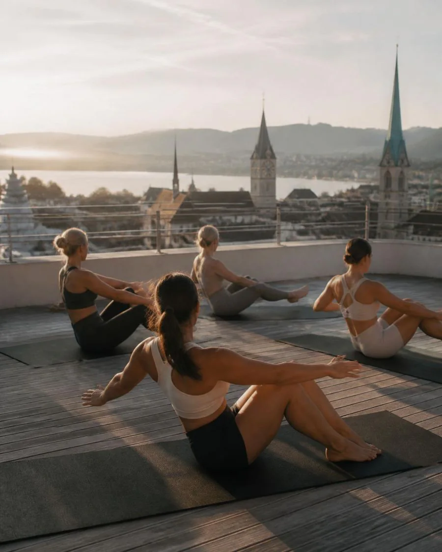 Pilates-Klasse auf einer Rooftop-Terrasse über Zürich im Morgenlicht